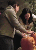 Jackie and Heather carving pumpkins.